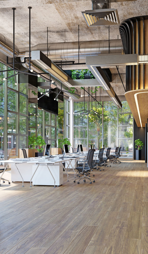 Modern office interior featuring large windows, wooden flooring, and stylish workstations with plants, emphasizing a bright and open workspace design.